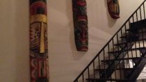 Three 6 foot masks hung over a staircase